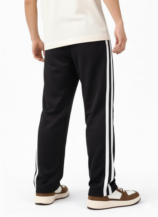 Black track pants with white stripes worn by a person on a white background